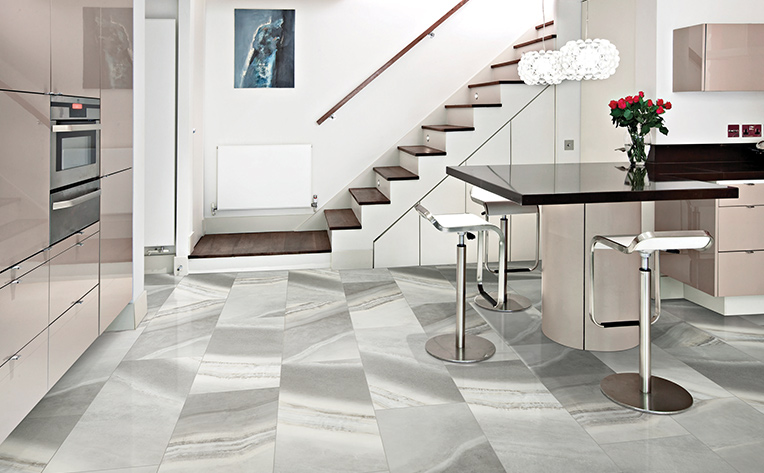 kitchen with stairs and black island with grey metal chairs